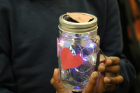 A student shows off her decorated solar power lantern. 