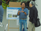 Student explaining a research poster to faculty. 