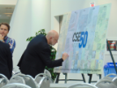 Panelist Bob Fritzinger (center) signs the CSE 50th anniversary poster.