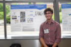 Eric Oliverio with his poster at poster session. 