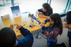 Students use solar-powered LEGO cranes to lift their LEGO creations. Photo: Nancy J. Parisi