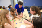 UB aerospace engineering student Andrew Dianetti (center) puts together a radio with (from left) Shannon Lynch, Kylie Naylor, Annabella Bogart and Sarah Cumming. The girls are from Troop 981 at Sweet Home High School.