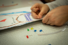 LED diodes add some extra sparkle to a child's artwork at the "Paper Circuits" activity.