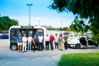 UB transportation researchers pose in front of Olli, the autonomous electric shuttle, in the Center for Tomorrow parking lot. 