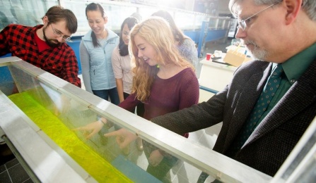 Photo of Prof. Jim Jensen and students working on sluice gate in hydraulics lab. 