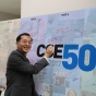 Chunming Qiao signs the 50th Anniversary banner. 