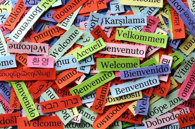The world "Welcome" written on papers in several different languages. 