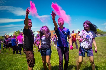 Indian students throwing pink color into the sky on UB's North Campus. 