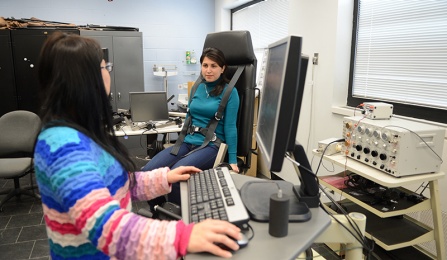 photo of two graduate students working in an ISE lab on workplace safety research. 