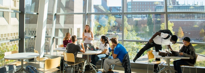 students engaged in conversations in the atrium of davis hall. 