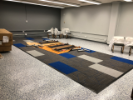 August 29, 2019. Furniture installation continues. GP Flooring set and finished the additional two rows of carpet tiles.