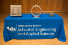 Large-scale model of the Pledge of the Computing Professional lapel pin, large-scale model of the Order of the Engineer ring, and the Engineer of the Year award. Photo credit: Onion Studio