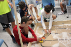 A group of students sets up their robots for the next round of testing. 