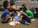A student group gathers around their laptops to collaborate during the Google Games event. 