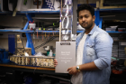 Incoming AIAA President and aerospace engineering student Aayush Kumar holds the Stan Powell Memorial Award in the team's Furnas Hall lab.