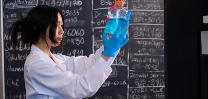 student examining chemicals in a bottle. 