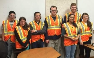 Students in safety vests and goggles on field trip to local employer. 