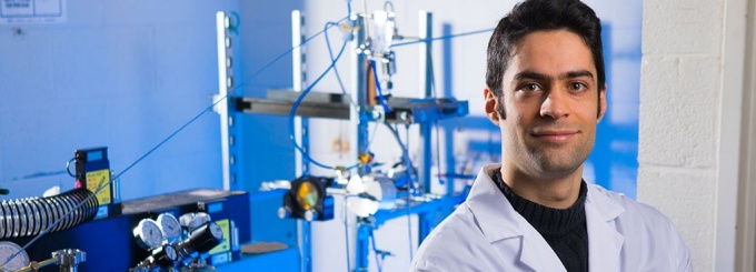 Chemical Engineer posing laboratory in front of experimental equipment. 