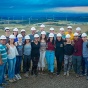 Students stand in front of windmill field with hard hats during a study abroad trip to Costa Rica. 