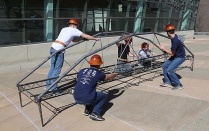 Students assembling a steel bridge. 