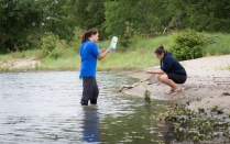 Students and faculty collect water samples from a beach. 