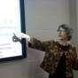 Female researcher points toward a project screen. 
