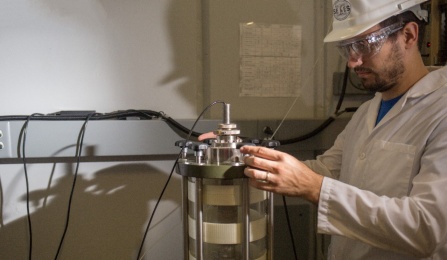 photo of student and triaxial testing system.