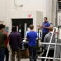Photo of students and lab technician during materials steel testing. 