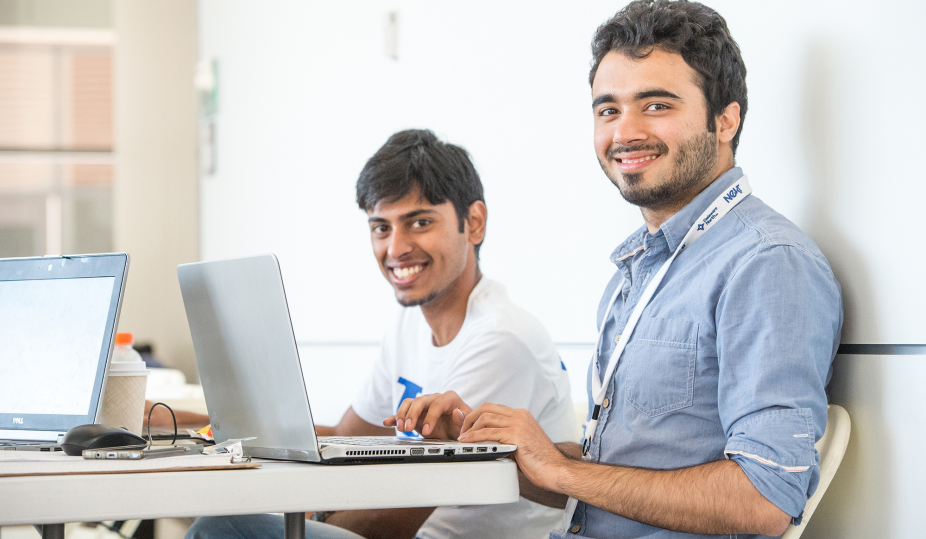 computer science students work at laptops. 