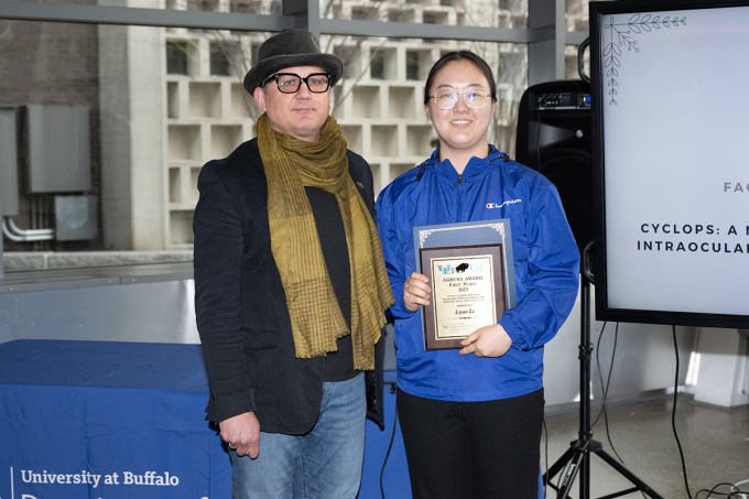 Zoom image: Associate professor Jaric Zola presents the award for first place in the 2023 Agrusa Competition to Liyao Li. 