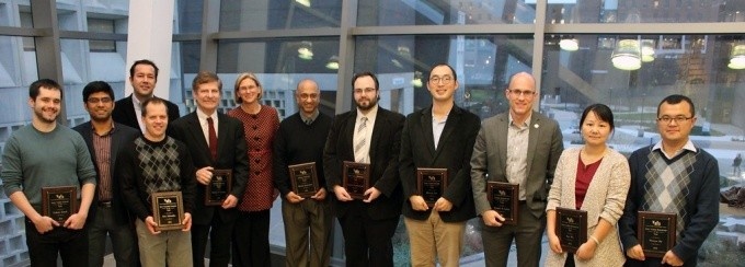 Engineering Awards Ceremony. Pictured are: Luke Ziarek, Varun Chandola, Murat Demirbas, Kris Schindler, Edward Furlani, Dean Liesl Folks, Bharat Jayaraman, unknown, unknown, Kemper Lewis, unknown, Wenyao Xu. 