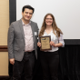 CSE undergraduate research award recipient Jessica Bruhaus stands with professor Tevfik Kosar. She holds a plaque with the award name and her name. 