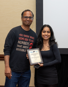 Katherine Johnson Chair in Artificial Intelligence Professor Atri Rudra presents the CSE Undergraduate Leadership award to Ahana Battacharya. Each of them smile while Battacharya holds the plaque. 