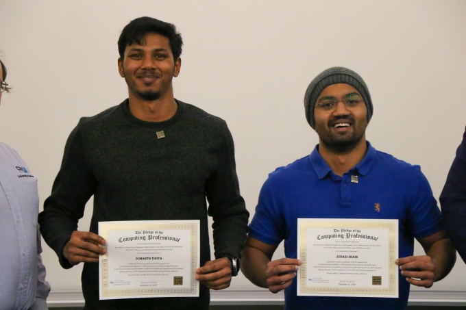 CSE students smile while holding their award certificates. 