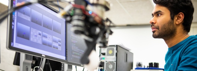 Zoom image: A man focuses intently on his computer monitor