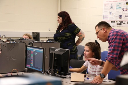 A professor and several students in a computer science and engineering lab. 