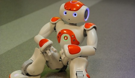 Close-up of an orange and white Aldebaran Nao humanoid robot. 