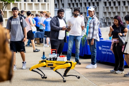 UB Computer Science and Engineering students operate a robot outside Davis Hall. 