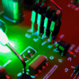 a device lights up while it pokes what looks like a computer circuit board. 