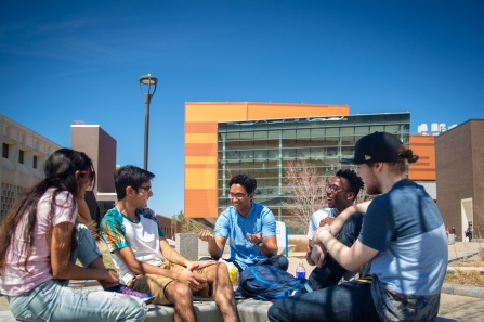 Group of students chatting in Grace Plaza outside Davis Hall during on a sunny day. 