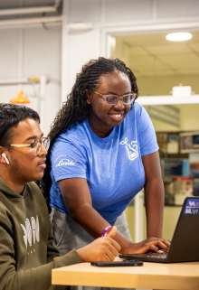 A DREAM student assistant trains other students on equipment in the DREAM makerspace. 