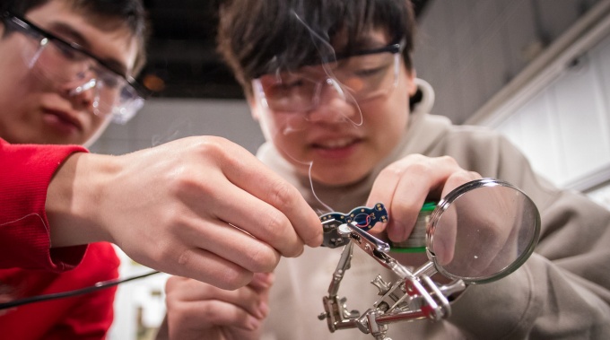 two engineering students tinker. 