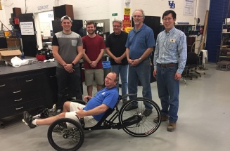 Curt Senf shows off his new trike designed by mechanical engineering students Caleb Walters and Austin Powers for their senior design project. 