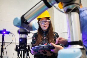 Woman wearing hard hat working in a lab. 