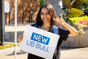 Female student holding sign that says, "New UB Bull.". 