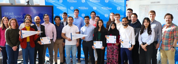 Around 20 Participants of SEAS Lightning Talk competition standing in Davis Hall with winners positioned in the front holding their certificates. 