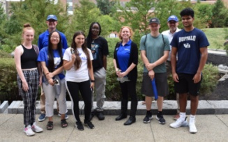 Students and staff pose for a group photo outside. 