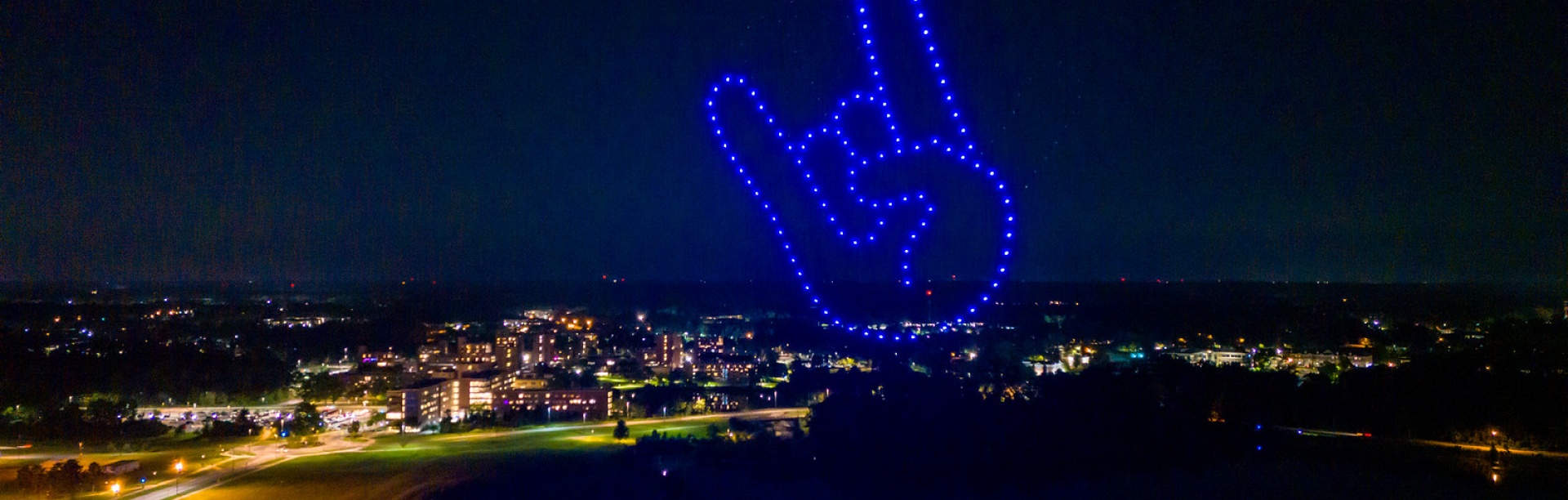 Drones in the night sky in shape of UB horns upduring Welcome Back Blast Pep Rally on the Student Union Field.