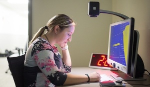 Woman sits at computer. 