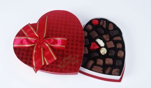 A box of chocolate in the shape of a heart. 